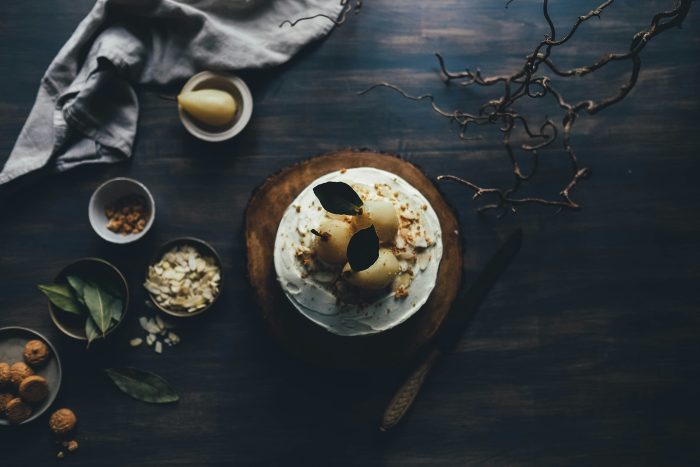 Peren mooi opgemaakt op creme met bakjes met laurierbladeren en noten